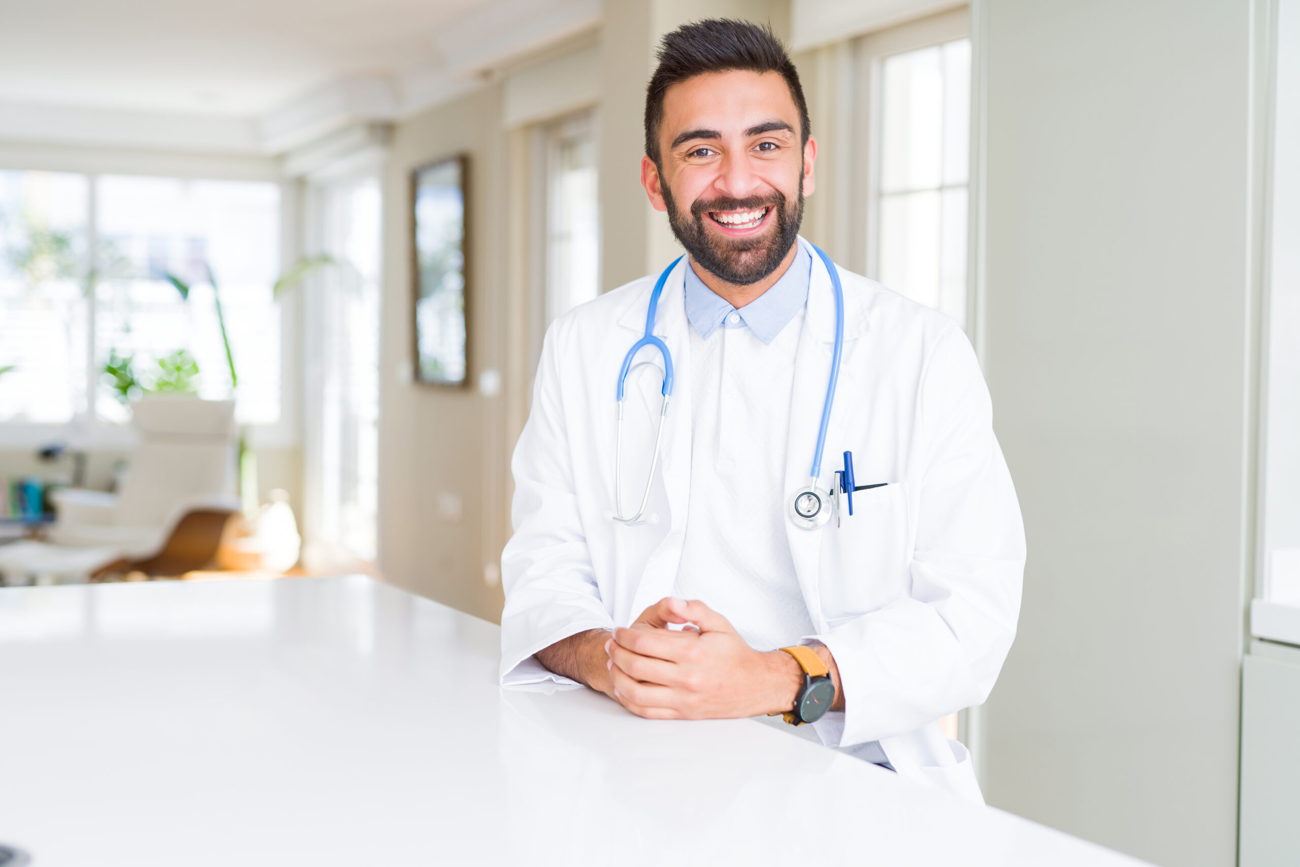 Handsome hispanic doctor man wearing stethoscope at the clinic with a happy and cool smile on face. Lucky person.